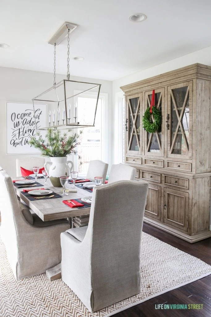 Gorgeous dining room with linen slipcovered chairs, reclaimed wood table and beautiful wood hutch. Love the Darlana Linear Pendant Chandelier over the table!