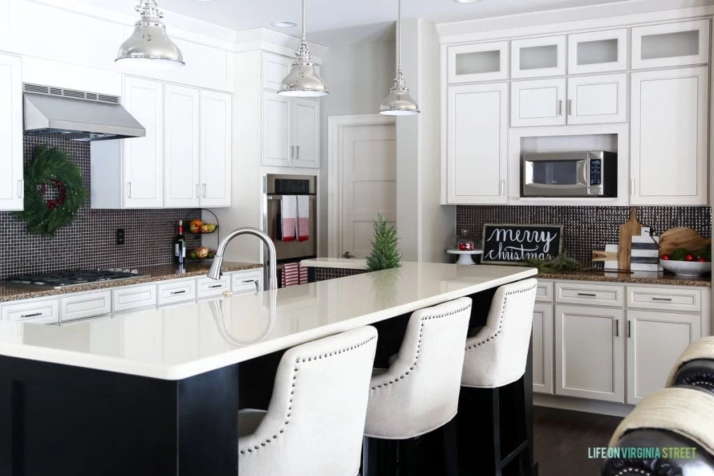 White kitchen with small Christmas tree on counter.