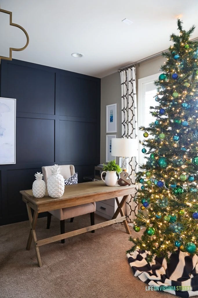 Decorated Christmas tree in office with wooden desk.