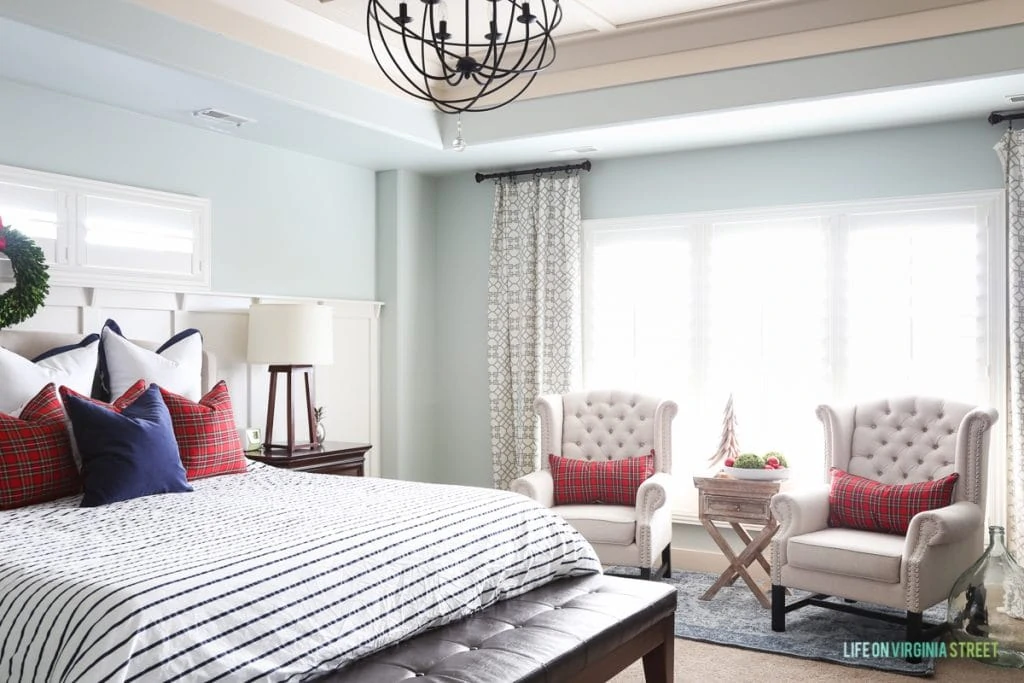 Red plaid pillows on bed in master bedroom.