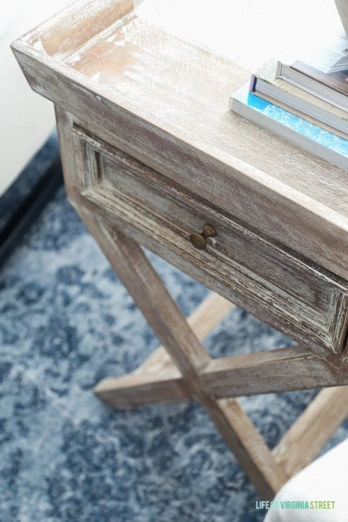 Wooden side table with books on it.