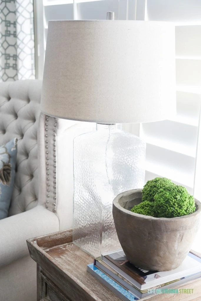 Lamp on side table with clay pot and moss inside the pot.