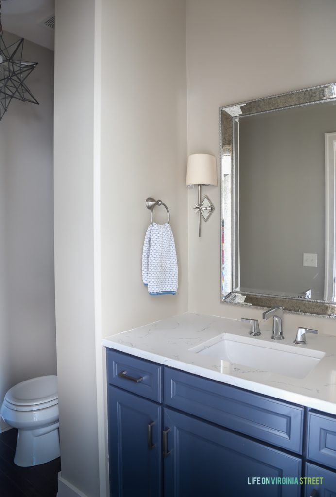 Powder bathroom makeover with star light fixtures, Delta Faucet faucet, Behr Castle Path Walls and Benjamin Moore Hale Navy Cabinets. Love the fresh, nautical vibe! Countertops are Daltile One Quartz in the Luminesce color