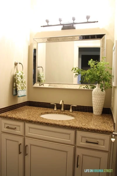 I tried to refresh the powder bathroom with a new silver-framed mirror, but that didn't do much to lighten the space. More updates were needed.