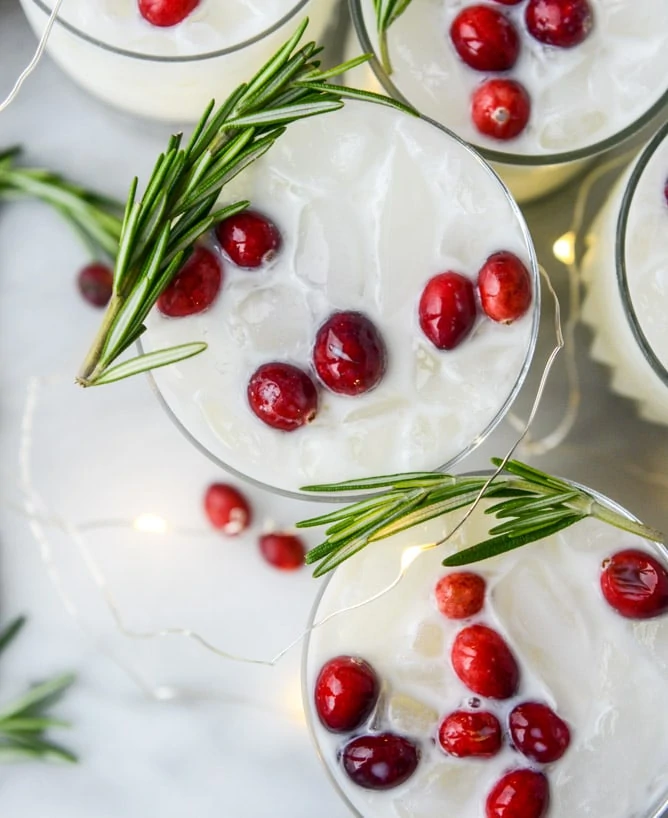 White Christmas Margarita Punch - So festive with red cranberries and green rosemary to compliment this white drink. Perfect look for Christmas!
