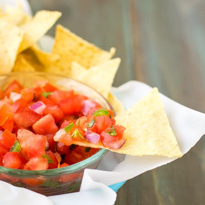 Tomato salsa in a bowl with corn chips.