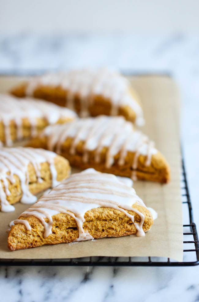 Scones with icing cooling on a baking rack.