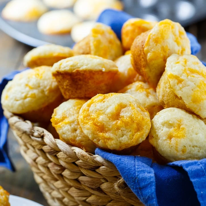 Cheesy biscuits in a basket with a blue cloth.