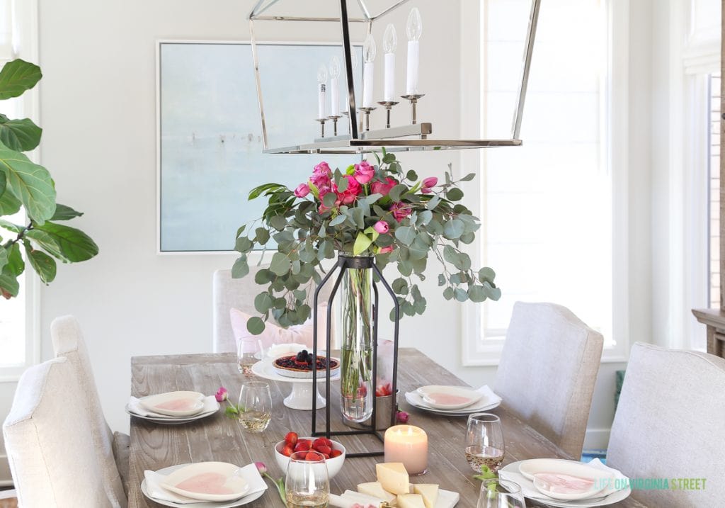 A large centerpiece of pink flowers on the dining room table.