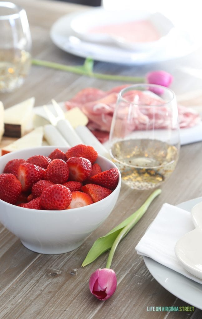 Valentine's Day entertaining and tablescape with strawberries, tulips and a meat and cheese tray.