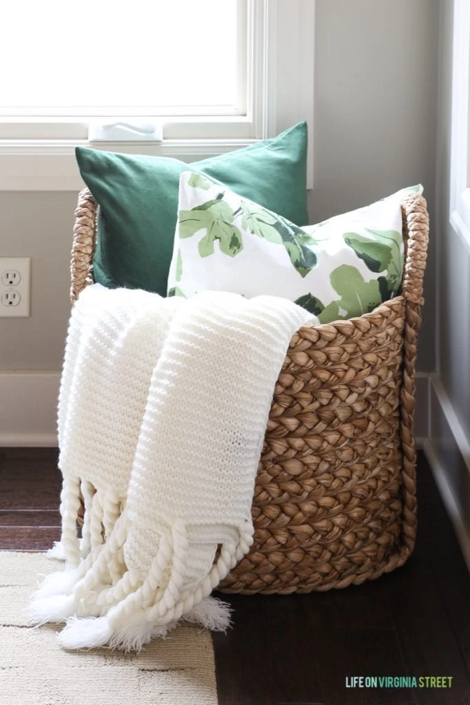 Pottery Barn Beachcomber basket with chunky ivory throw, green velvet and fig leaf pillow. 