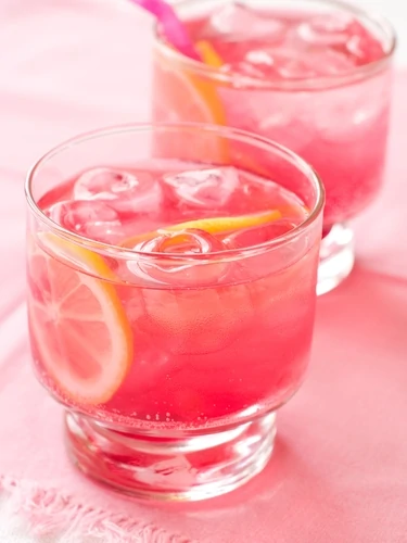 A pretty pink drink with lemons in it.