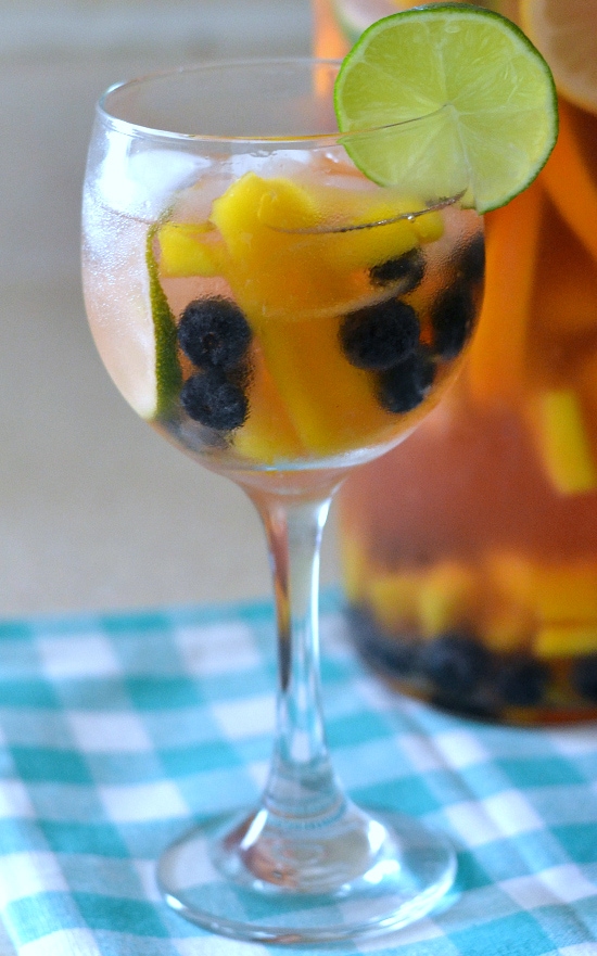 Moscato sangria in a champagne glass with fruit inside it.