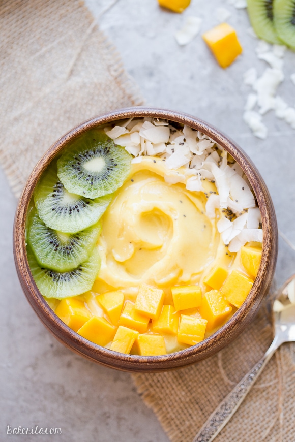 Mango pineapple smoothie bowl with slices of kiwi.