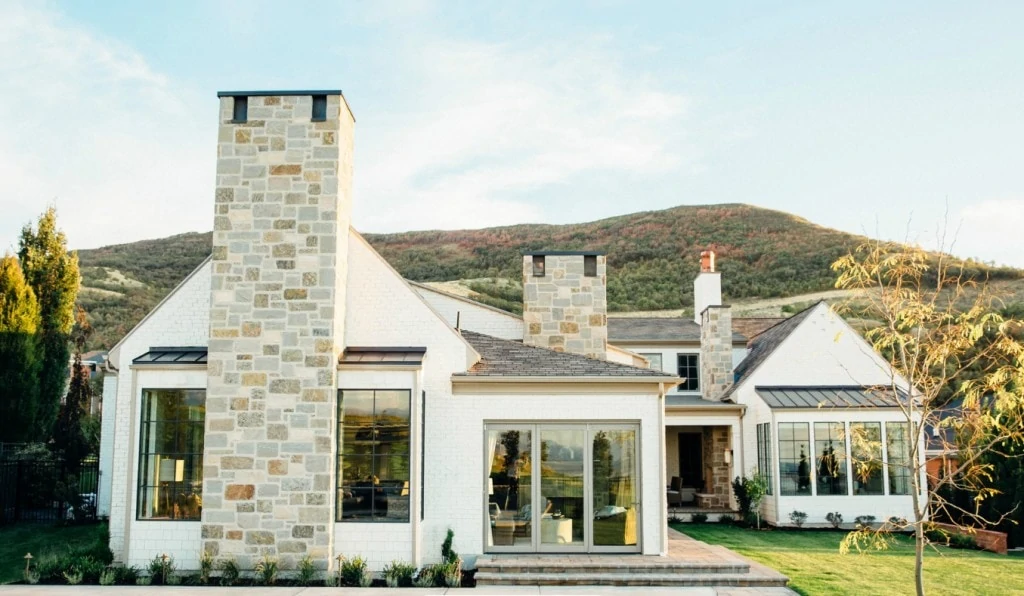 A white brick Utah home with black window trim and neutral stone accents. 