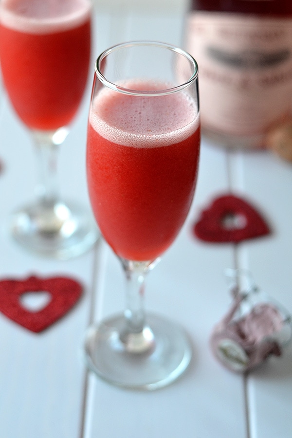 Strawberry bellini in a champagne glass on the table.