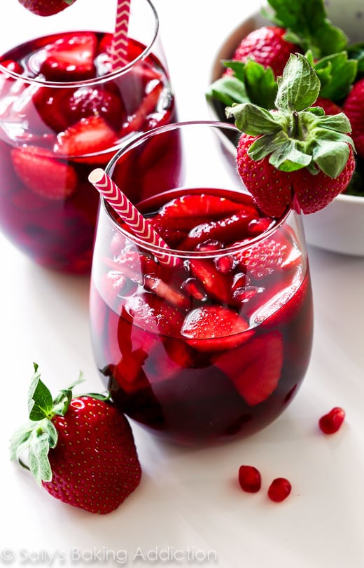 Strawberry Pomegranate drink in a clear glass with a straw.
