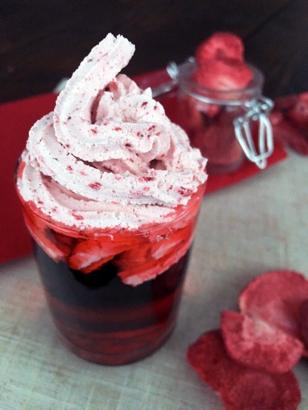 A strawberry khalua shooter with whipping cream on the top.