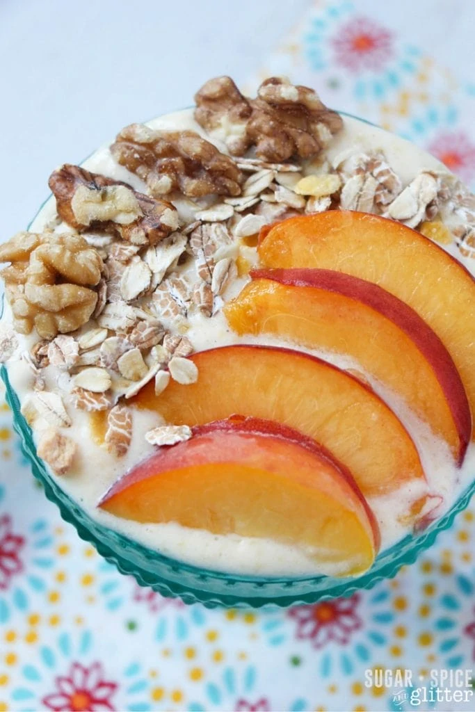 Peach pie smoothie bowl with peach slices and walnuts on top.