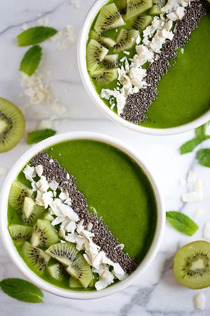 Tropical green smoothie bowl with slices of kiwi and chia on top.