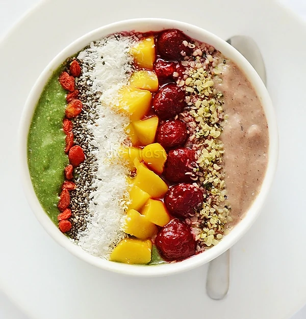 Superfood smoothie bowl on the table with a silver spoon beside it.