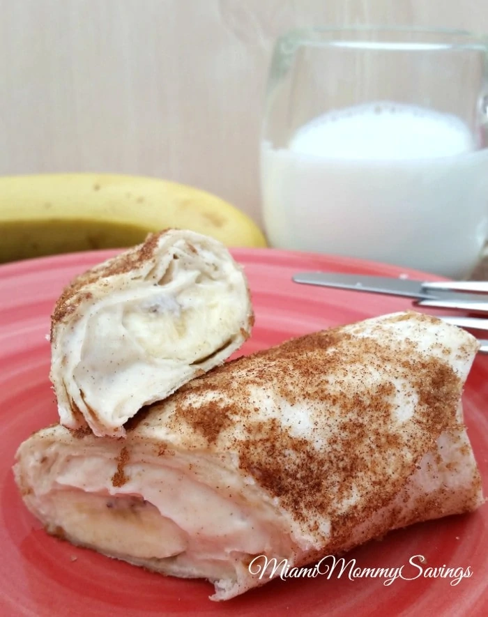 A banana and cream cheese breakfast burrito with cinnamon on top.