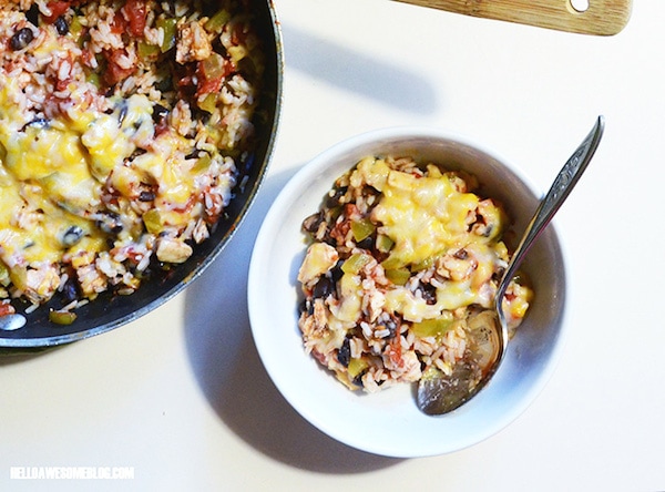 A skillet with cheesy chicken burrito and also a bowl filled with the burrito and a spoon.