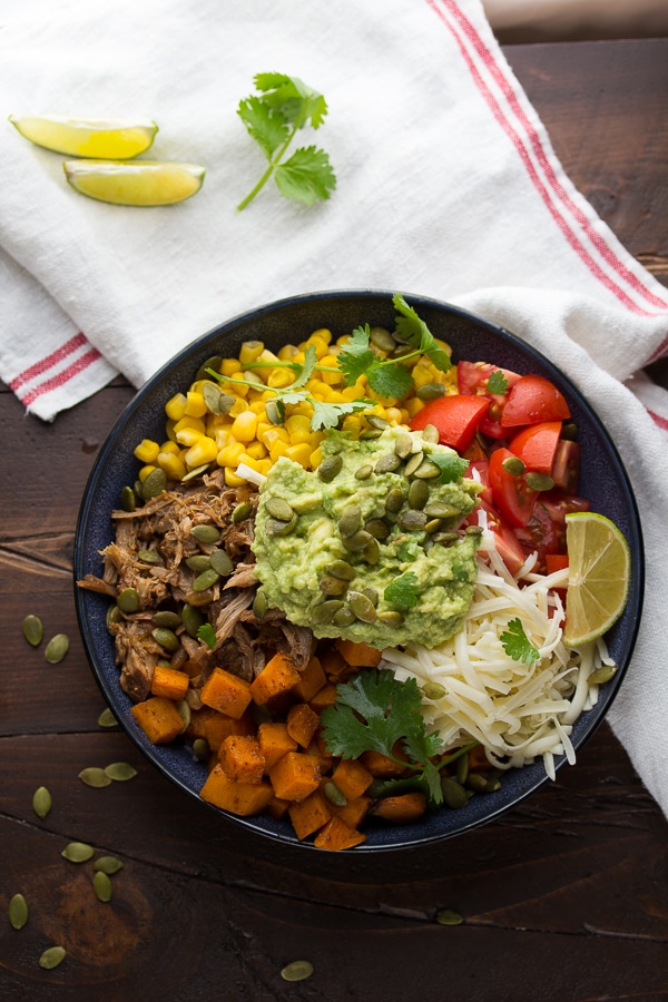 A maple pulled pork burrito bowl with corn, and guacamole.