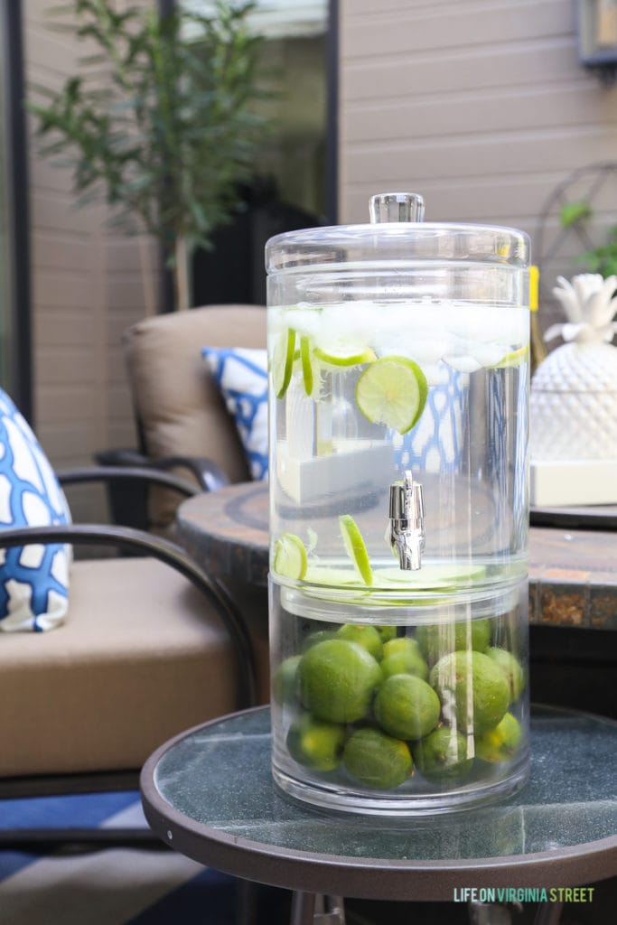 Two-tiered beverage dispenser. Love the limes in combination with this beautiful blue and white outdoor entertaining area.