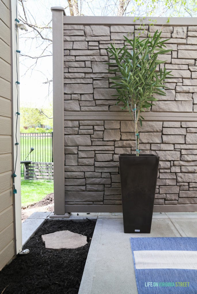 Gorgeous before and after tour of this outdoor courtyard entertaining space. Love the blue and white striped rug, the blue and white trellis pillows, the oleander topiaries, the limes in the beverage dispenser, the white ceramic pineapple, and more!