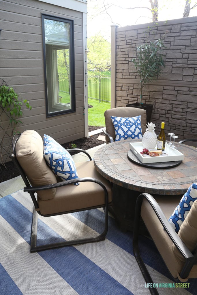 Gorgeous before and after tour of this outdoor courtyard entertaining space. Love the blue and white striped rug, the blue and white trellis pillows, the oleander topiaries, the limes in the beverage dispenser, the white ceramic pineapple, and more!