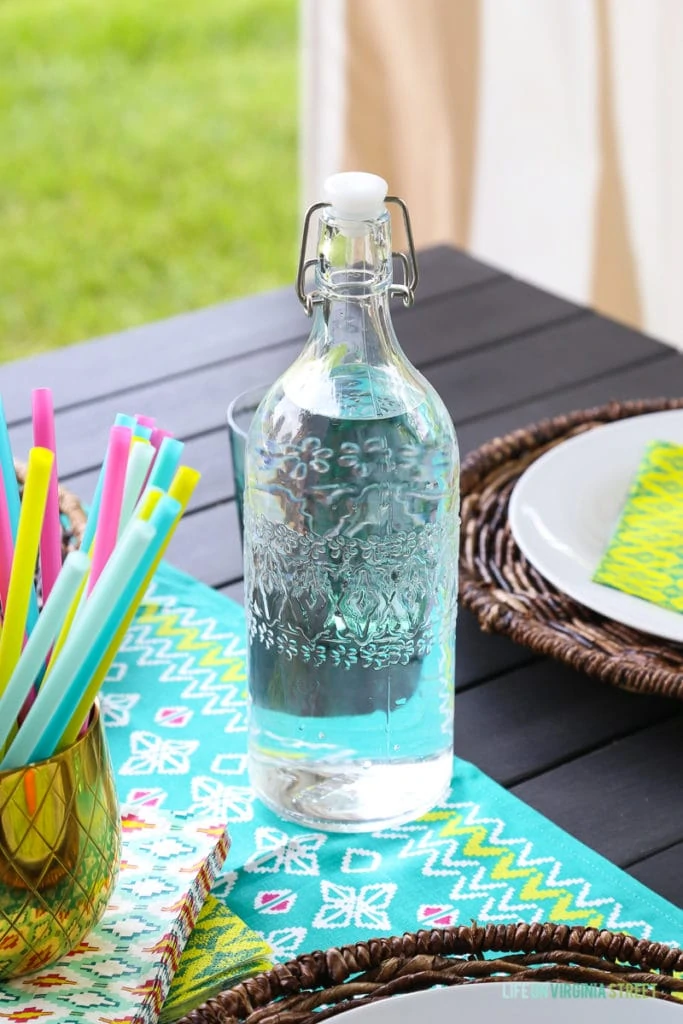 Water in a clear glass jar with a pattern on it.