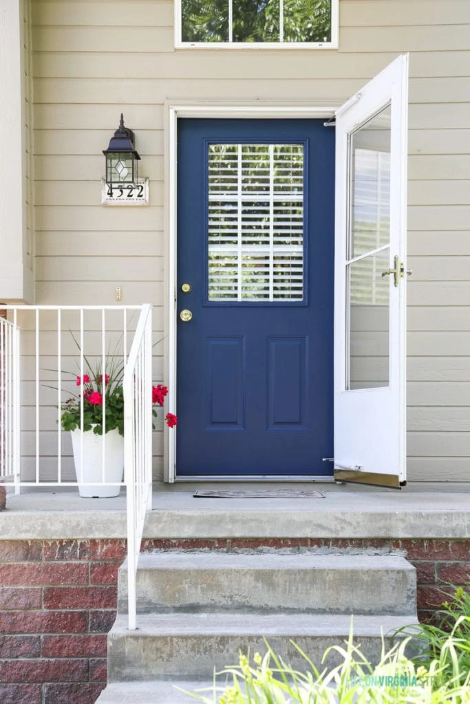 Adding curb appeal with a freshly painted navy blue door, new lighting, and hot pink geranium flowers. Paint color is TrueValue's Easy Care Ultra Premium in Ink Pad. Love the gorgeous, saturated blue color.