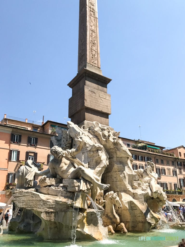 A fountain with Roman figures and rock work.