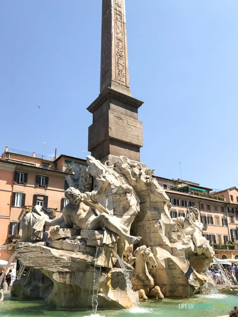 A fountain with Roman figures and rock work.