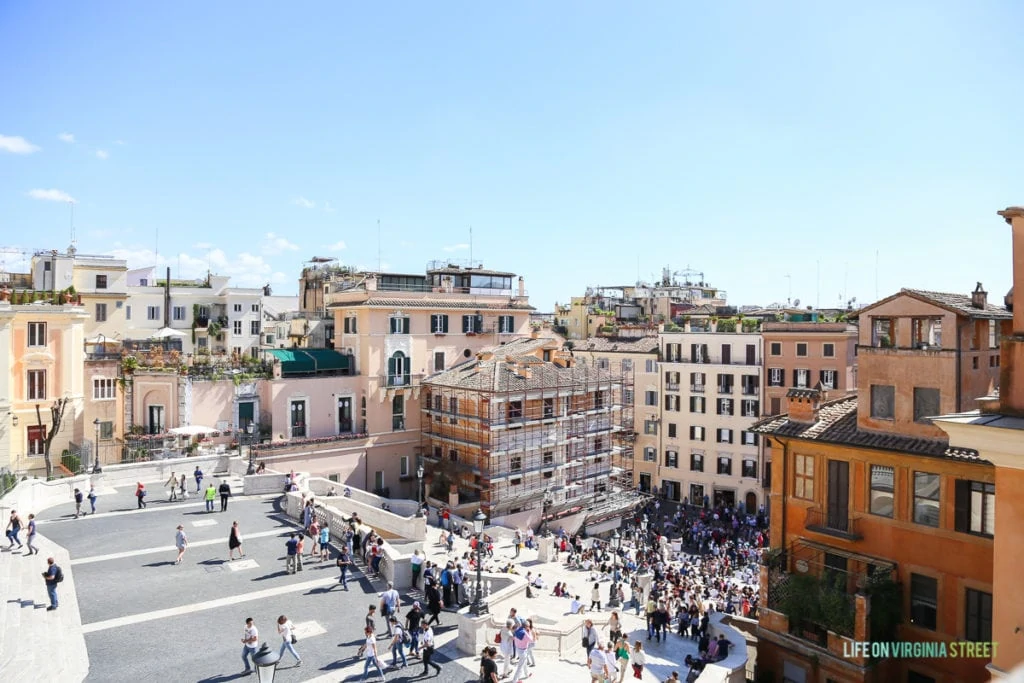 People gathered in a square in Rome on a sunny day.