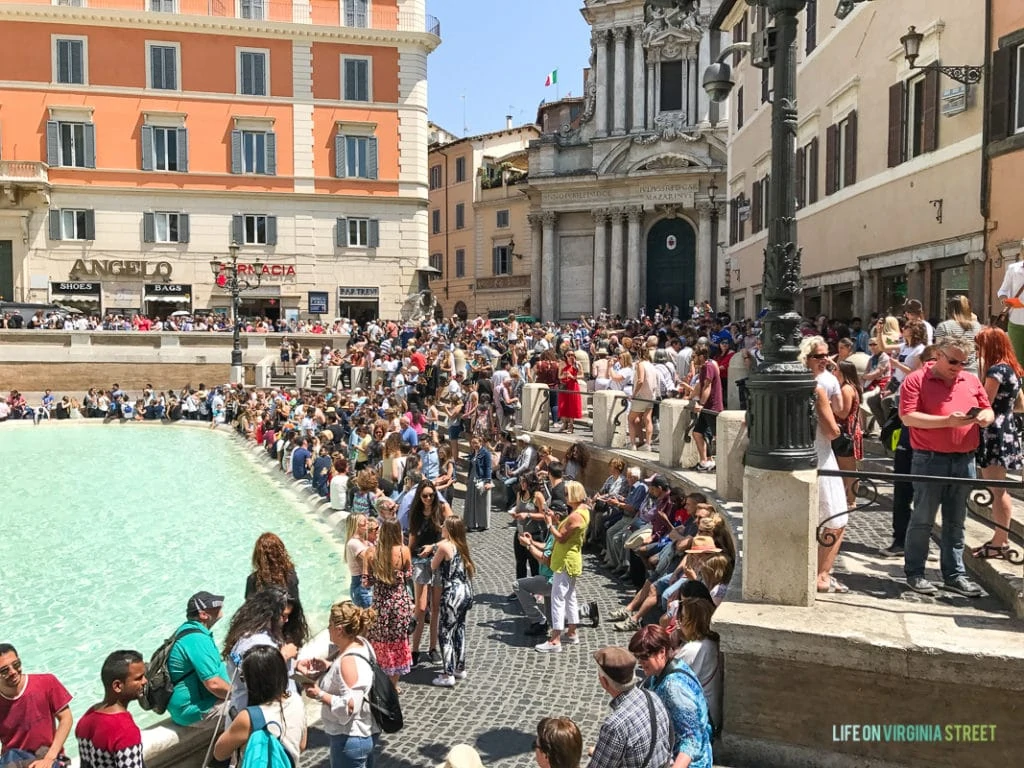 A lot of people in front of the fountain taking pictures.