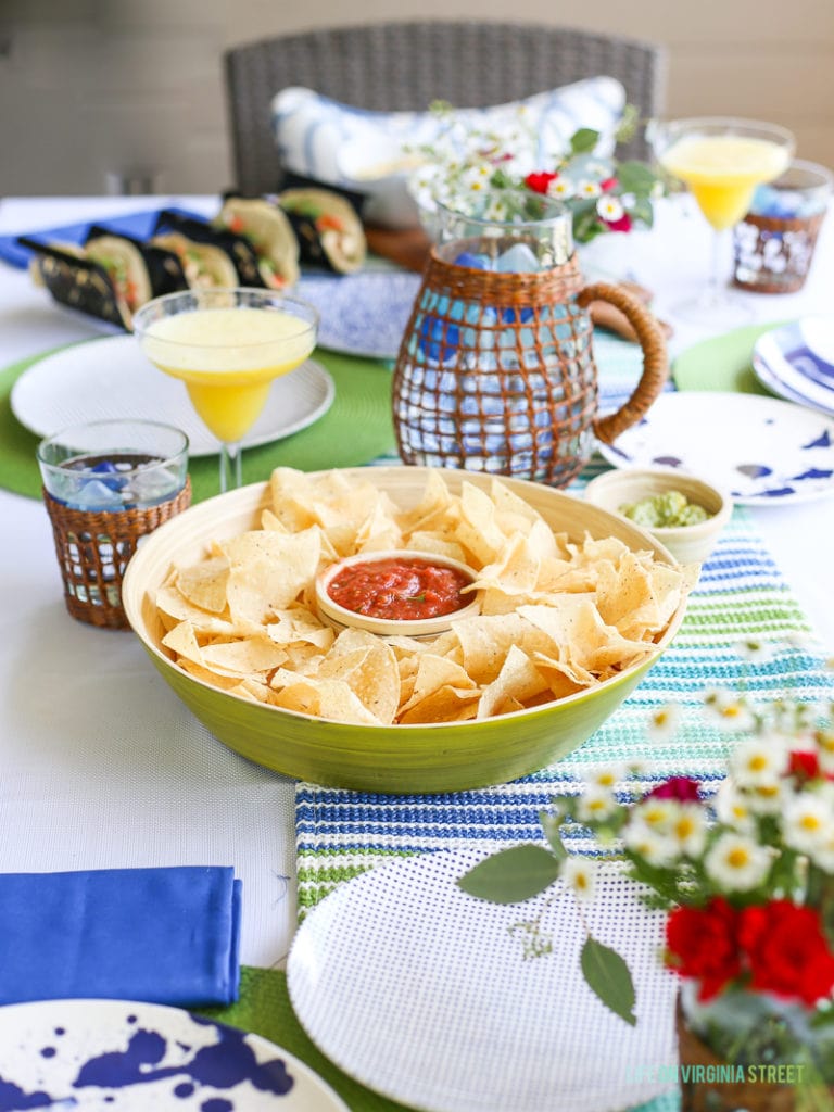 A large bowl filled with taco chips and salsa in the middle of the bowl.