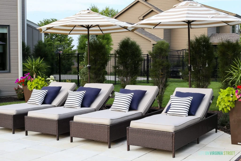 The pool deck with lounge chairs and large, colorful planters on either side of the chairs.