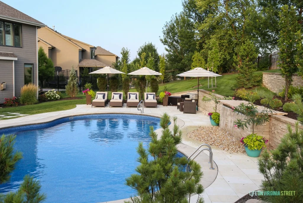 Here's a view of our beautiful pool. You can see the waterfall on the right and the pool chairs and umbrellas on the far side of the pool! Honest backyard pool review! We love our pool!
