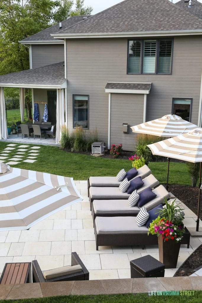 Here's an above shot of our pool furniture. Gorgeous oasis shaped vinyl pool. Striped umbrellas, striped outdoor curtains, checkerboard pathway, concrete travertine pavers, lounge chairs, navy blue pillows, striped pillows and planters filled with annuals.