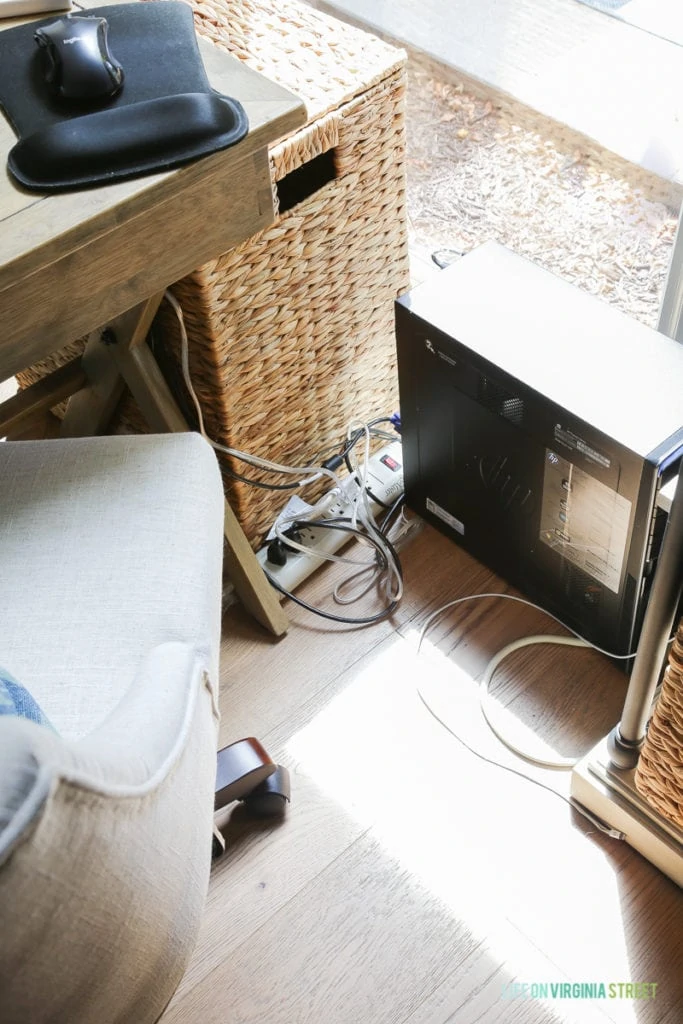 Computer cords on the floor beside the desk.