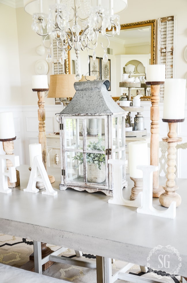 A table with candlesticks and a large mirror behind the table.