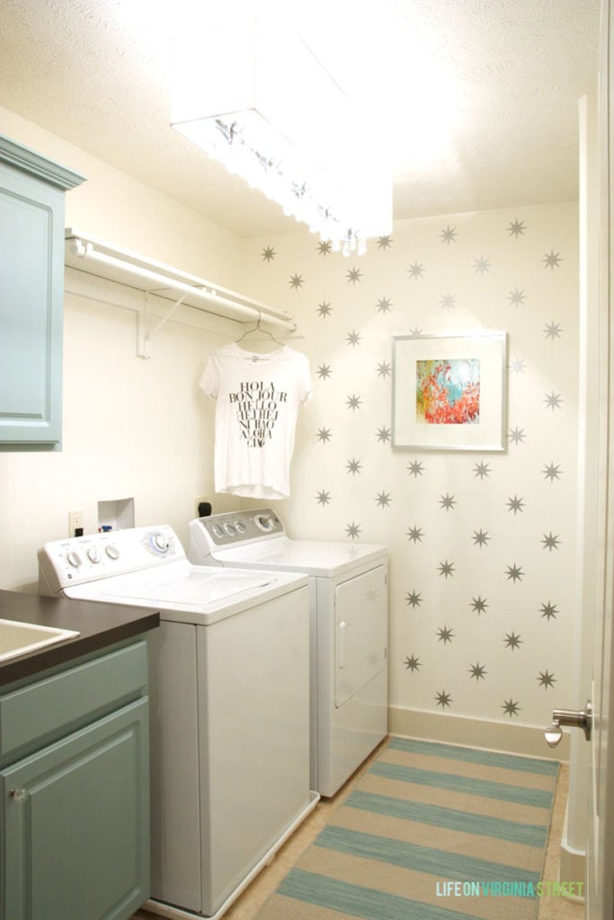 Laundry room with white washer and dryer and starry wallpaper and white walls.