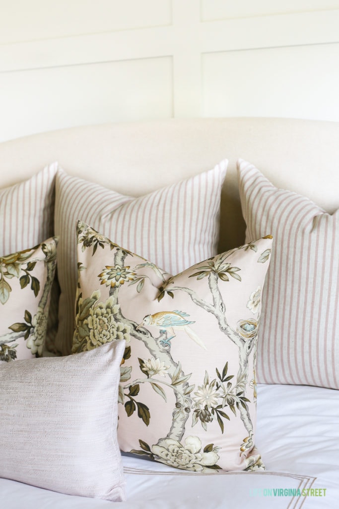 Blush toned pillows on bed.