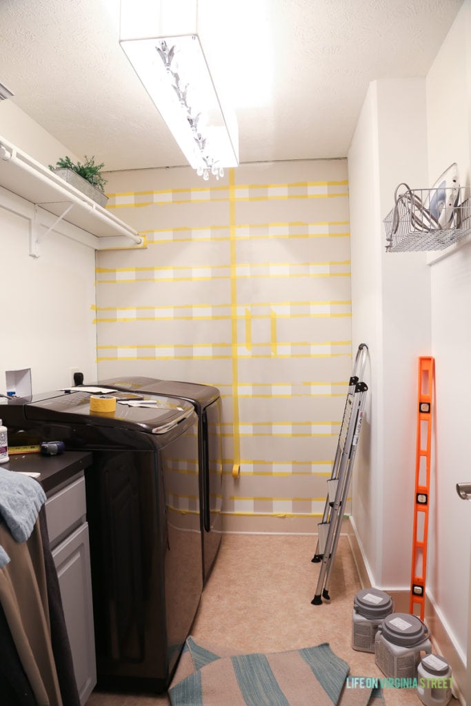 Taping off the squares with yellow tape on wall.