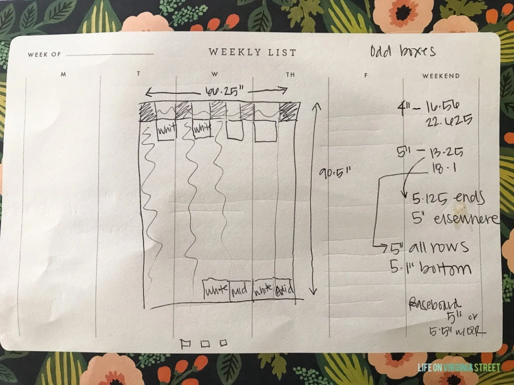 The plans and design drawn out and measurements on piece of paper for the laundry room.