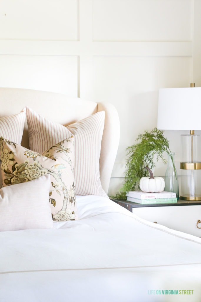 Blush toned pillows on white bedding.