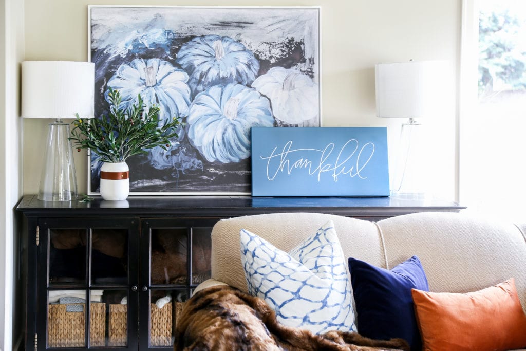 Gorgeous fall living room with navy blue, copper and neutrals. Loving the mix of velvet and faux fur. Also love the large blue pumpkins canvas art and 'thankful' canvas.