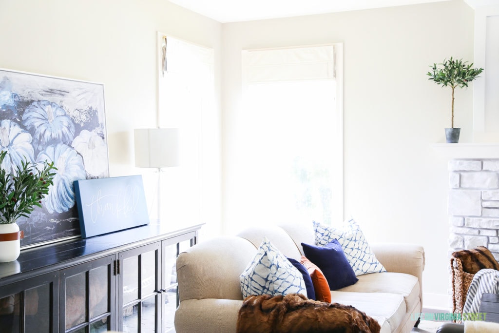 Light and bright fall living room with navy blue, copper and neutrals. Loving the mix of velvet and faux fur. Also love the large blue pumpkins canvas art and 'thankful' canvas.